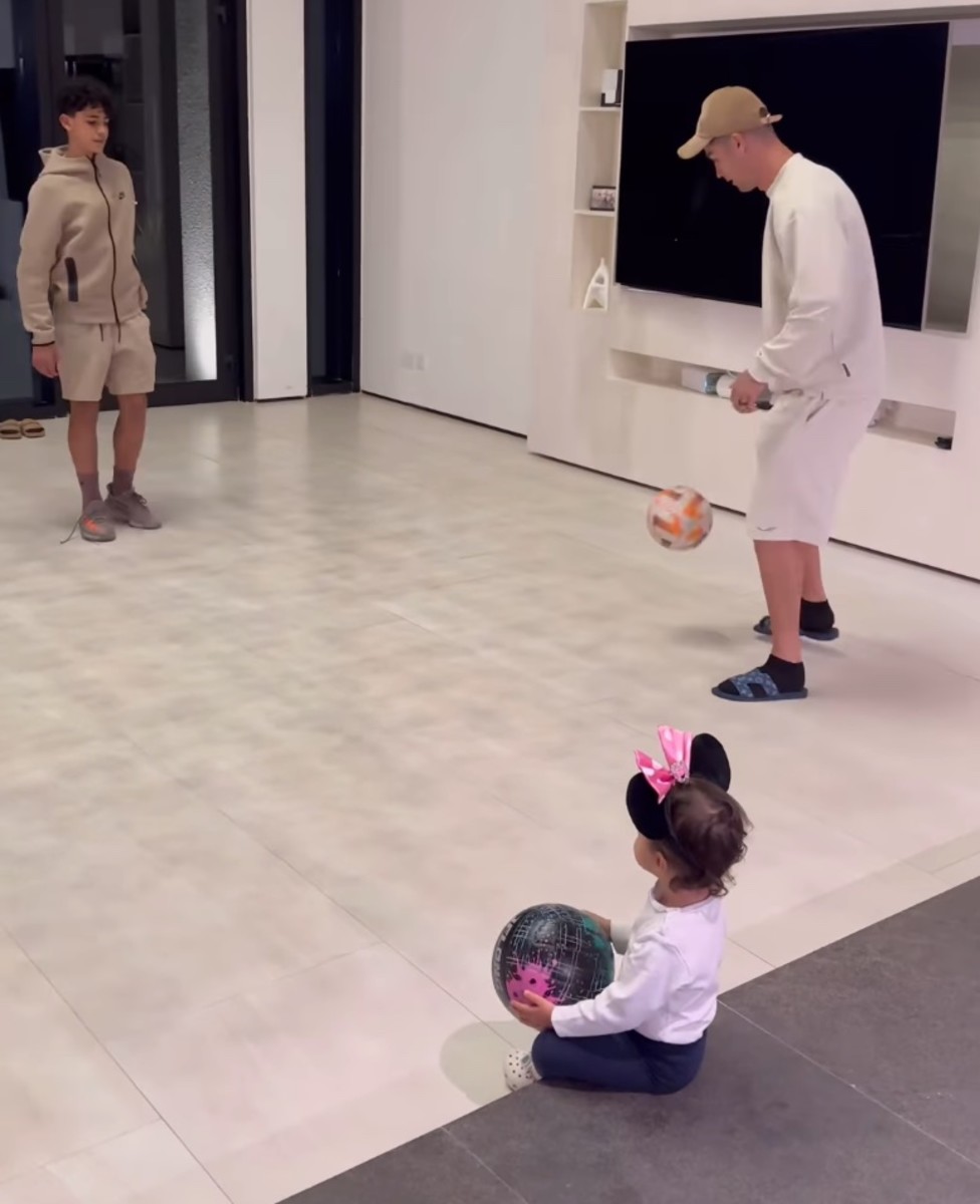 Cristiano Ronaldo pictured in December 2023 kicking a football towards son Cristiano Jr while daughter Bella watches on