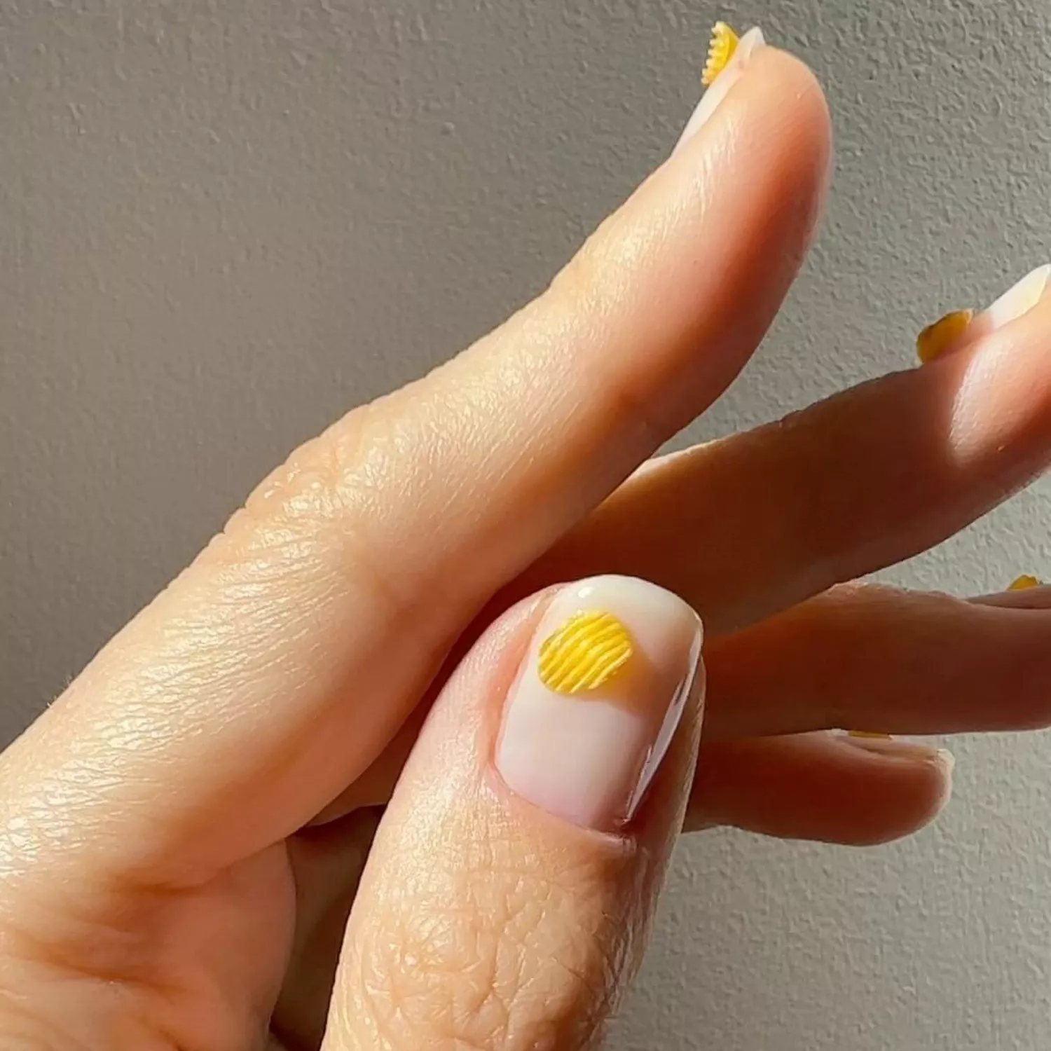 Close-up of manicure with neutral base and 3D potato chip designs