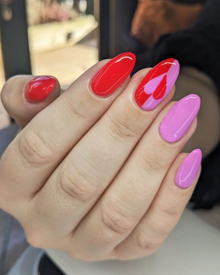 cute pink and red Valentines Day nails with simple heart nail art on the middle finger