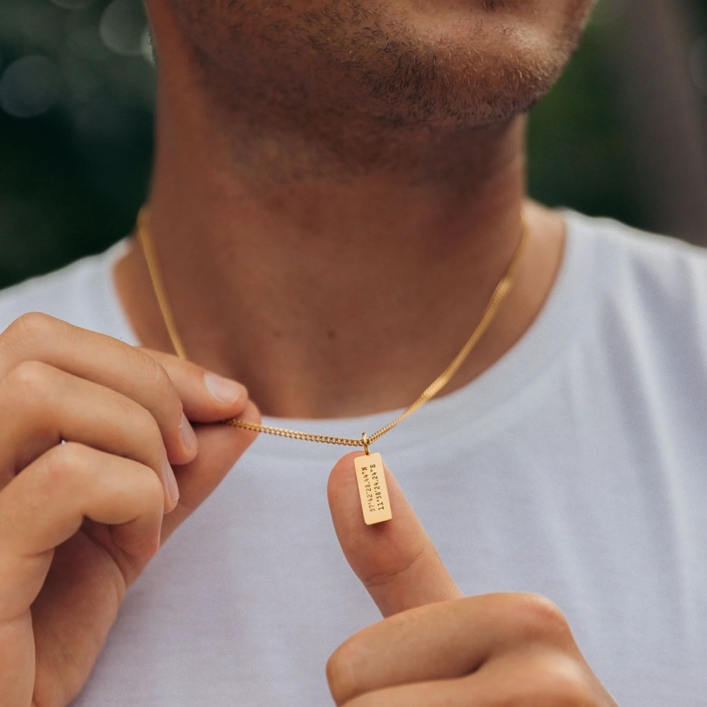 man wearing a personalized coordinates engraved gold necklace