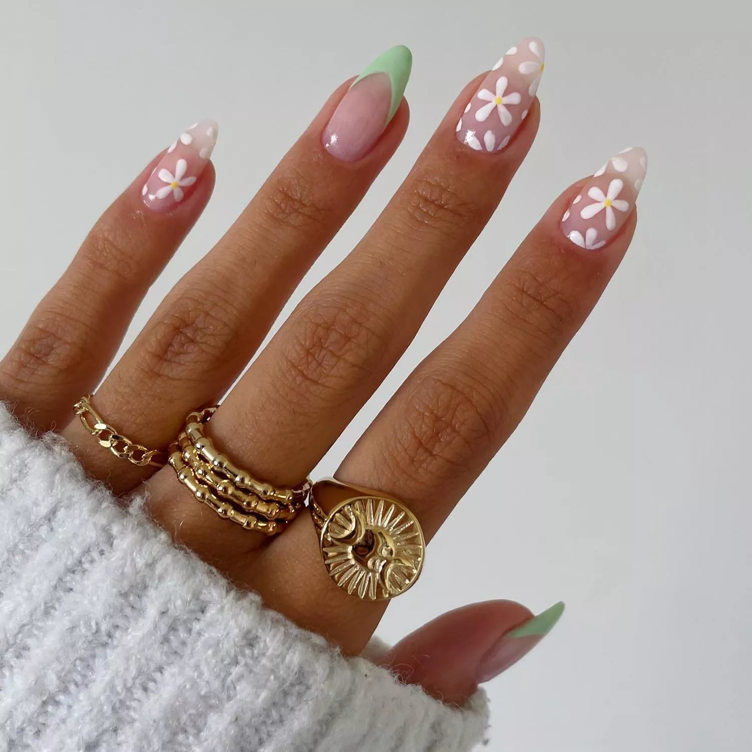 White retro floral manicure on negative space background with light green accent French tips