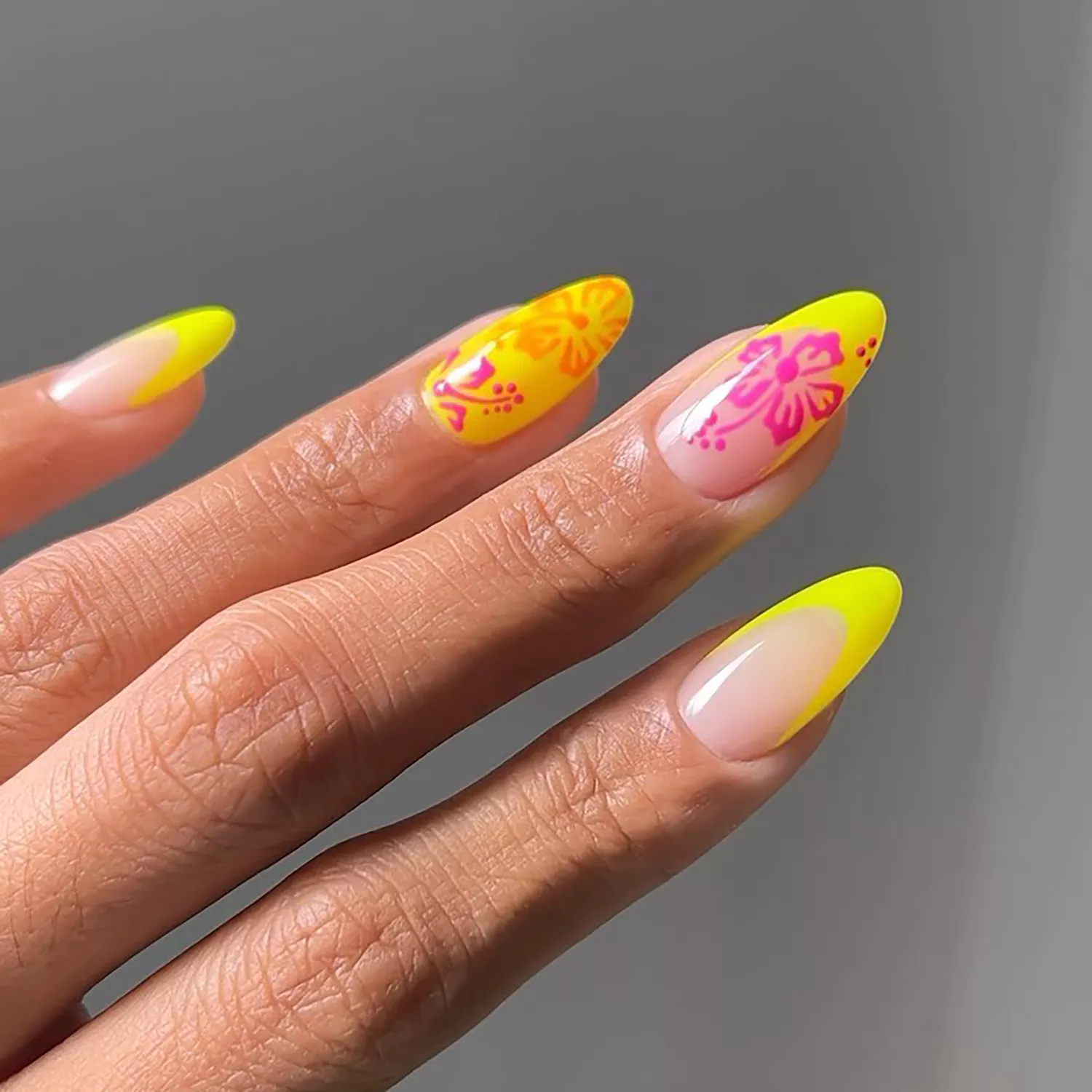 A yellow French manicure with hibiscus flower details