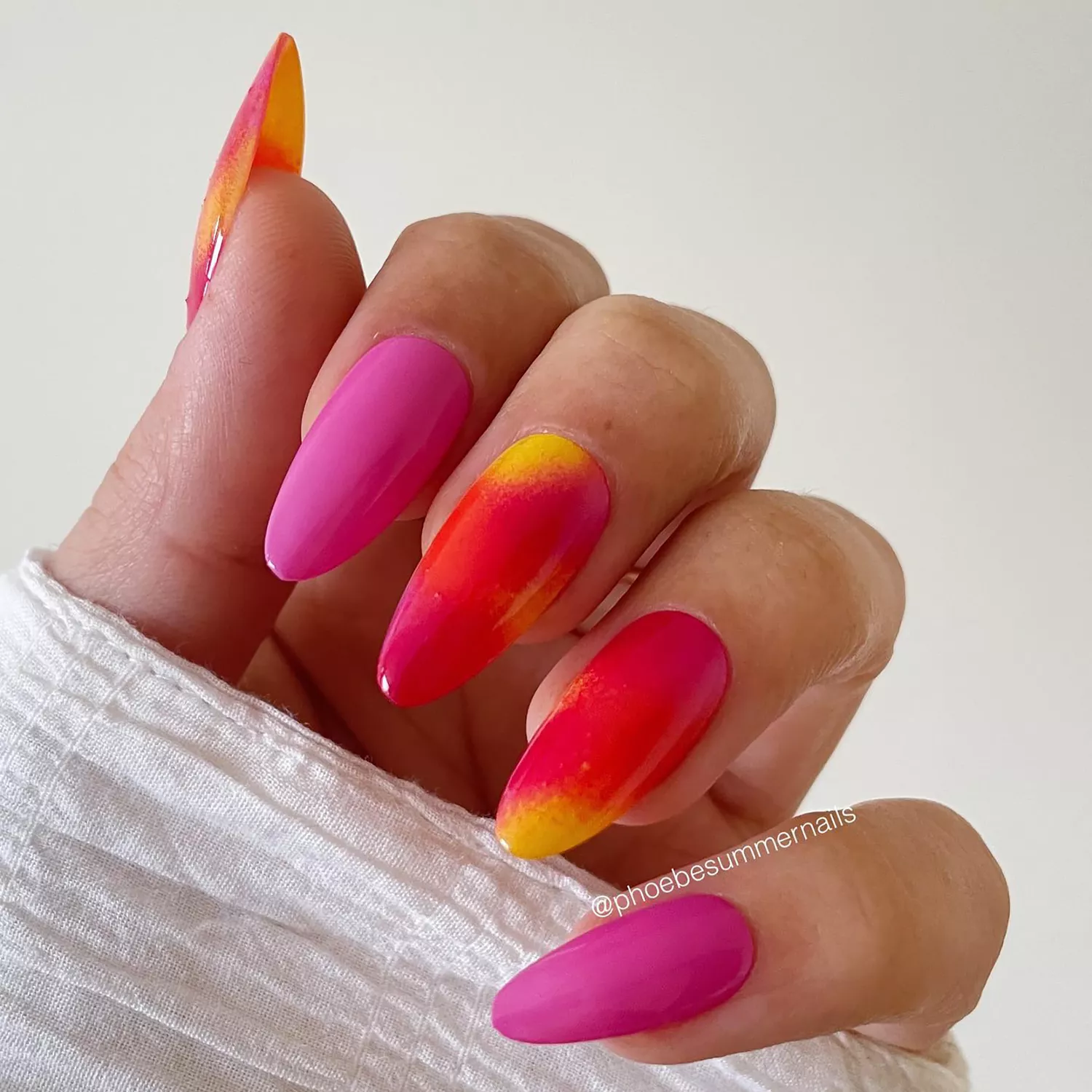 A manicure in shades of hot pink, red, and orange