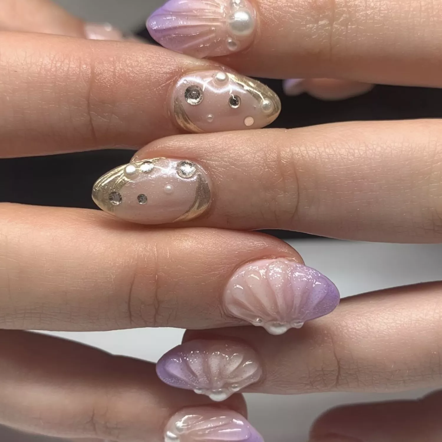 mani with seashells going in different directions 