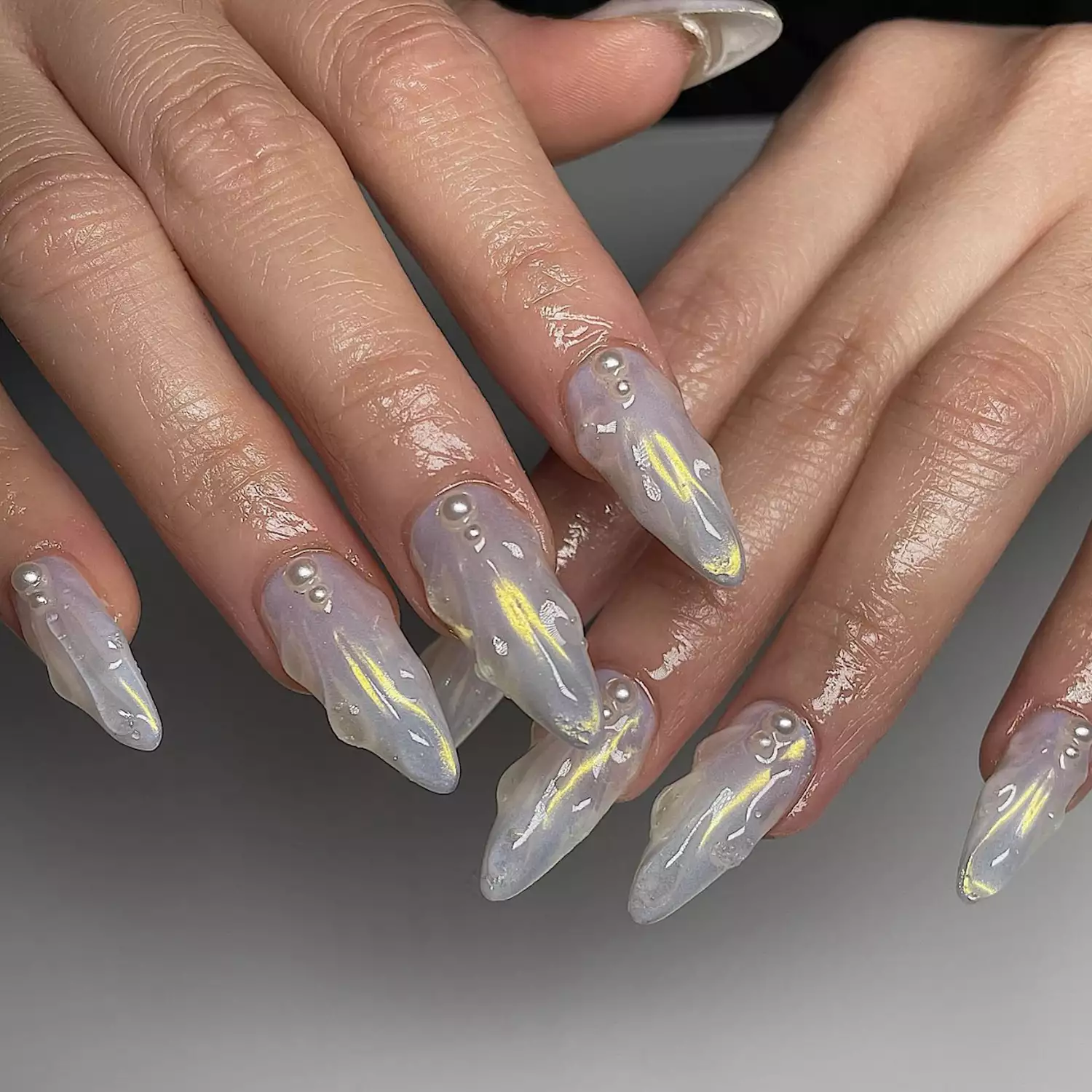 Iridescence and pearls on seashell nail design