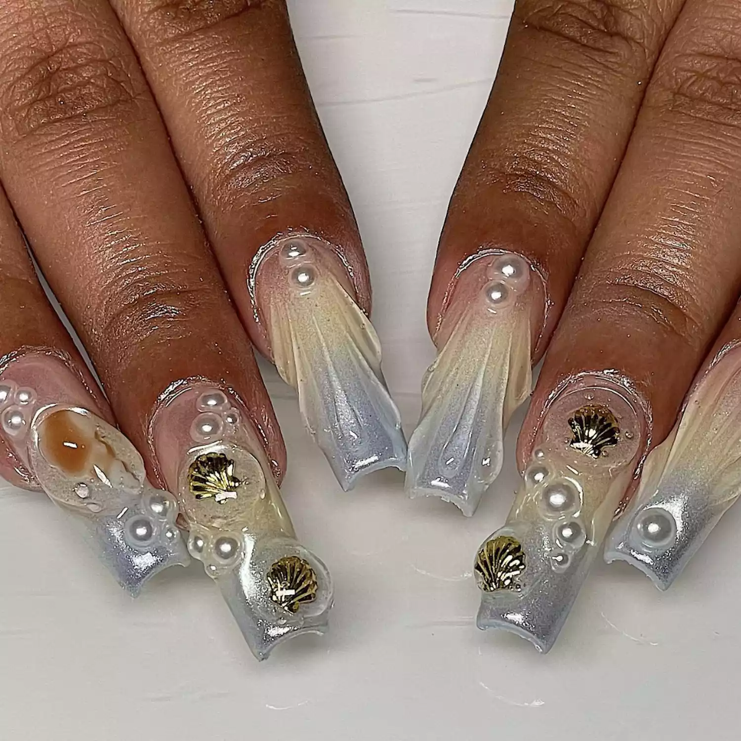 nails with seashells, shell accents, pearls and a sparkly pastel palette