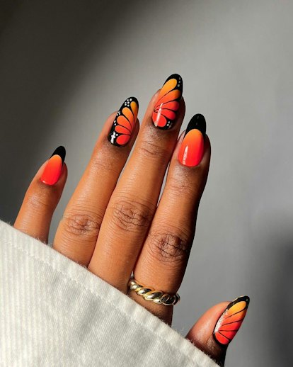 Orange monarch butterfly nail art is on-trend for 2024's Aquarius season.