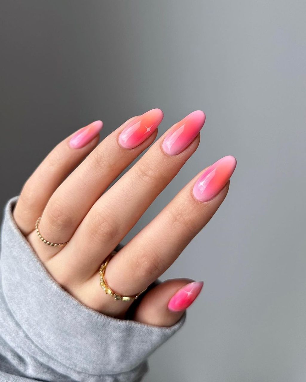 almond shaped pink and orange aura nails design with sparkle accent art