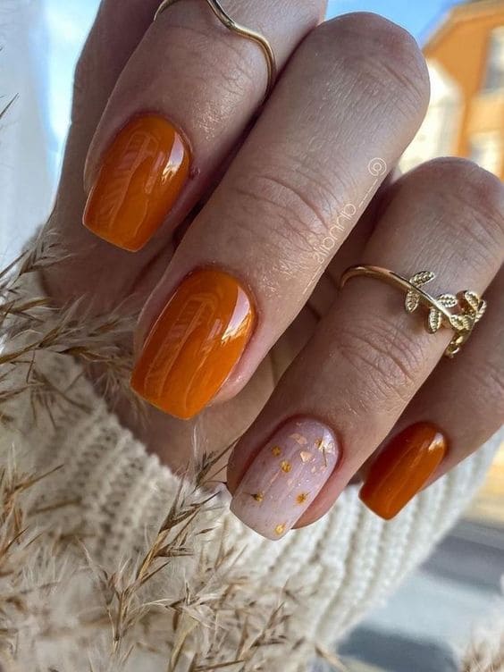 short burnt orange nails with gold foil accents 