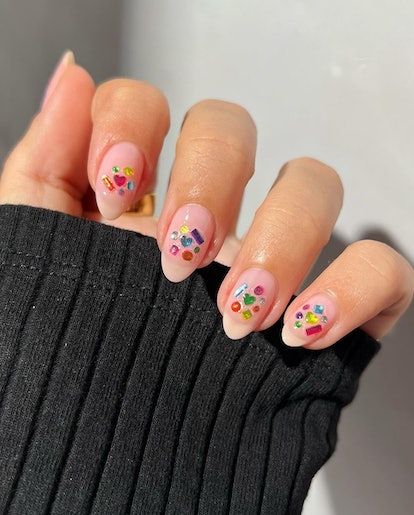 Lisa Frank-inspired colorful rhinestone nail adornments are on-trend for 2024's Aquarius season.