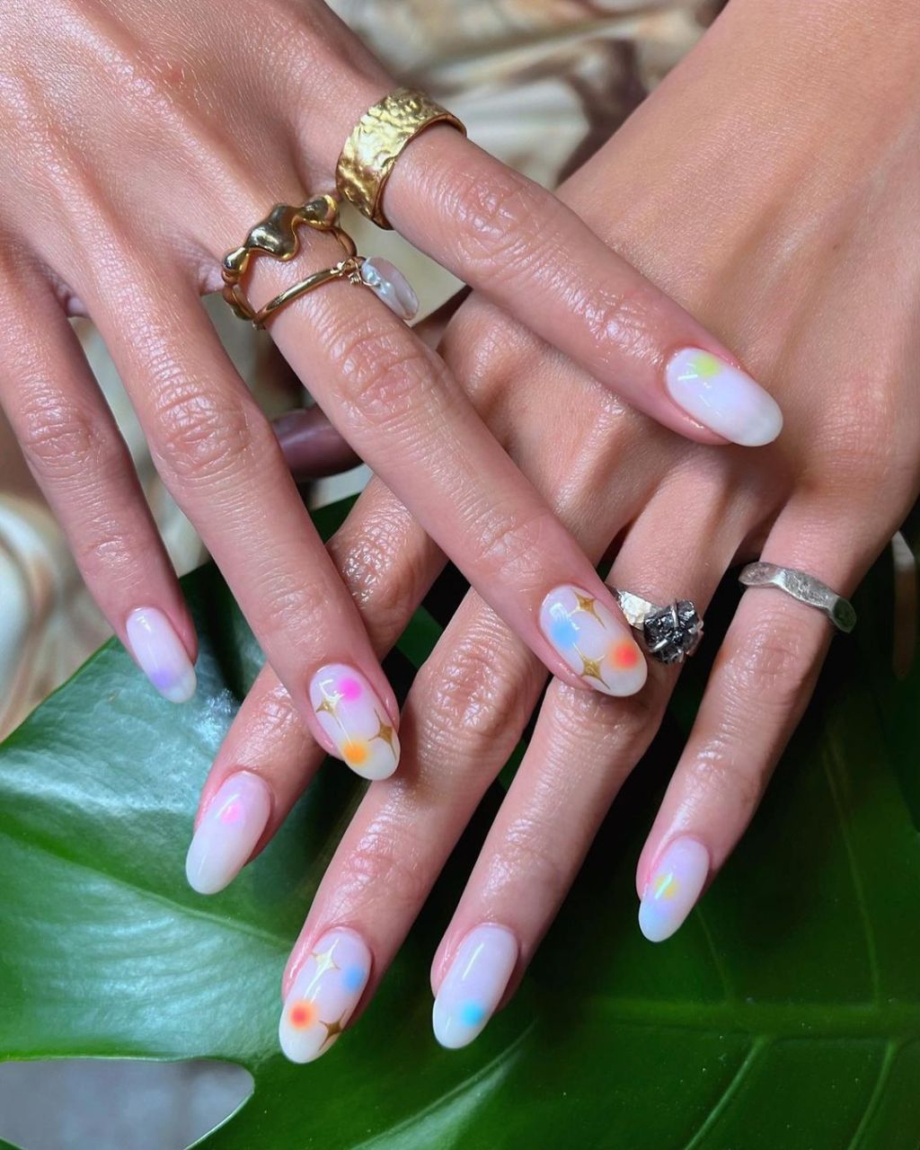 colorful almond shaped aura nails with a celestial gold sparkle design and blue, orange, pink, purple, and yellow aura dots