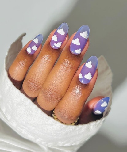 Cartoon cloud designs on lavender nails are on-trend for 2024's Aquarius season.