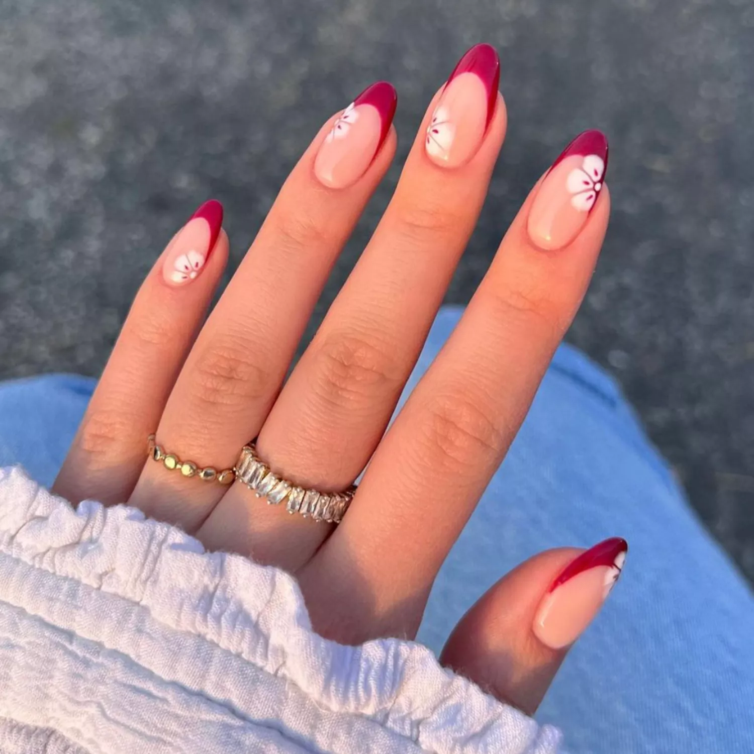 French manicure with dark red tips and hibiscus designs.