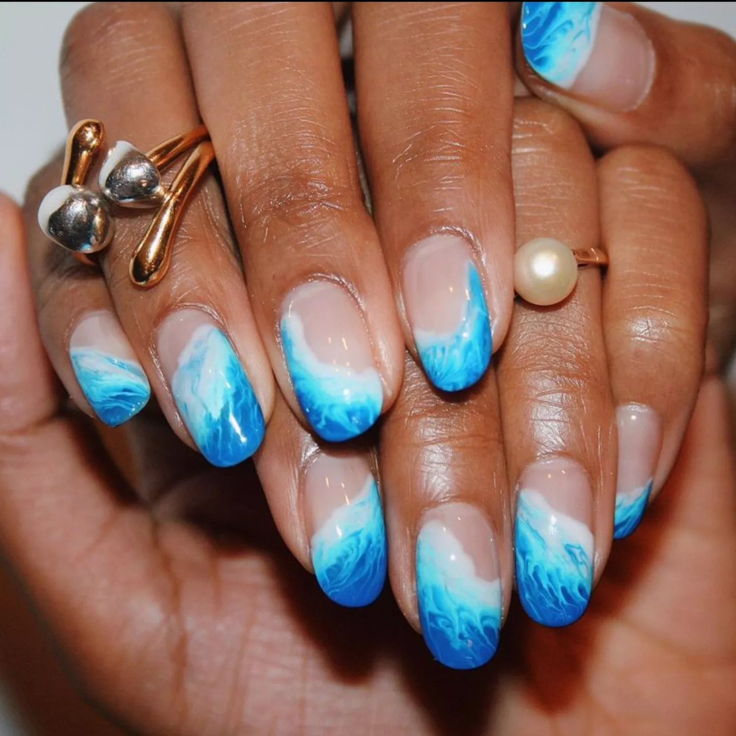 Negative space manicure with ocean waves.