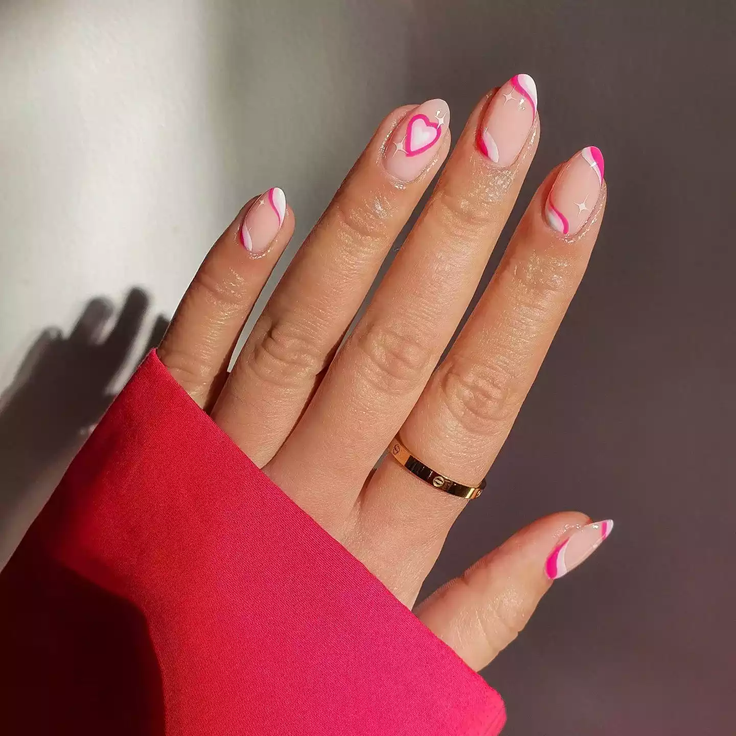 Neutral nails with pink and white heart and swirl designs