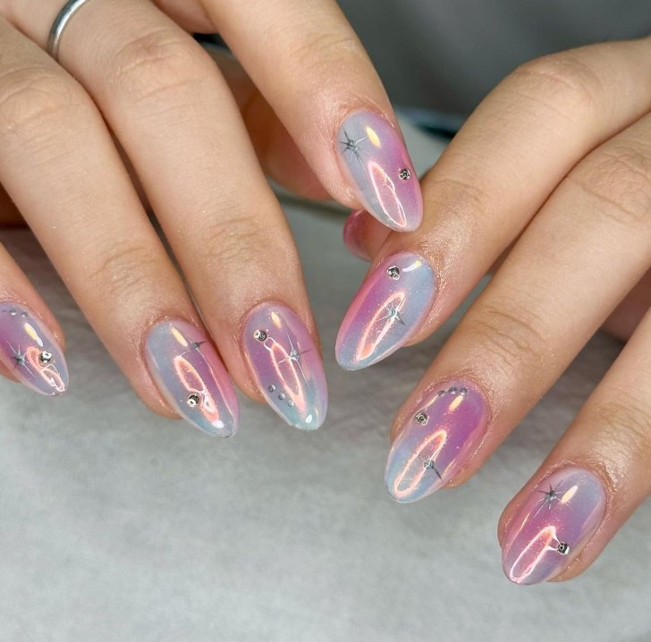 shimmery pink and blue press on aura nails with a silver metallic celestial design