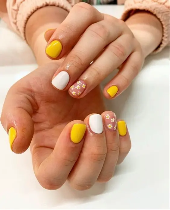 These short, squoval nails combine solid yellow with white accents and delicate daisy designs. The overall look is bright and cheerful, making it perfect for a sunny, floral-inspired summer style.