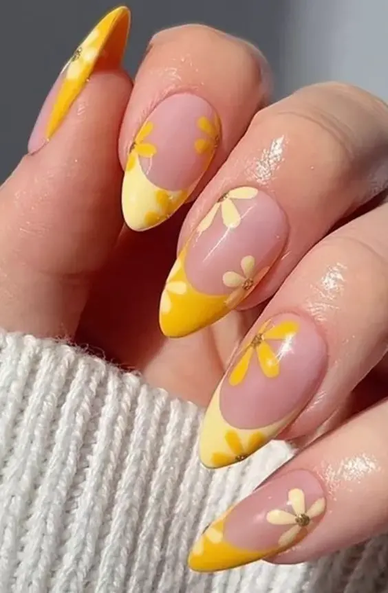 Stiletto-shaped nails with yellow French tips and daisy designs. This cheerful and whimsical style captures the essence of a bright summer day.