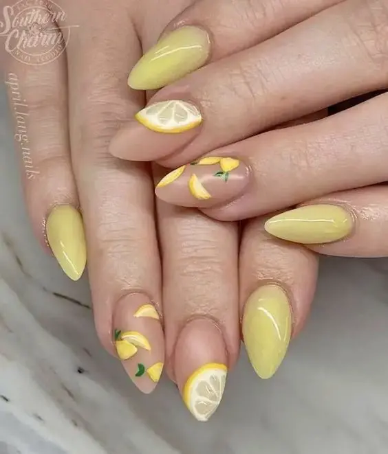 Stiletto-shaped nails with a soft yellow base, adorned with lemon slices. This refreshing design is perfect for summer, evoking a citrusy, bright vibe.