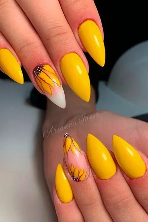 Vibrant yellow stiletto nails with accent nails showcasing hand-painted sunflower designs. This bold and cheerful style is perfect for embracing the warmth of summer.