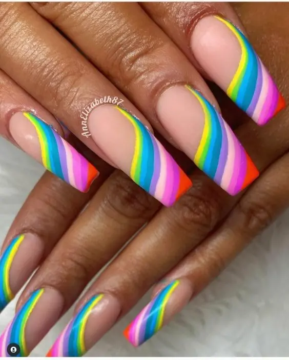 Long ballerina nails feature bright neon stripes over a clear tip. The stripes are precisely applied in a curved fashion, adding a dynamic twist to the classic French manicure. This design is perfect for a festive occasion or just to brighten everyday wear.