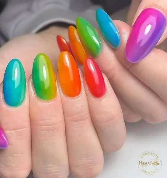 These almond-shaped nails showcase a striking gradient effect with each nail transitioning between two vibrant neon colors. This energetic design is ideal for those seeking a bold, statement look with a seamless blend of shades.