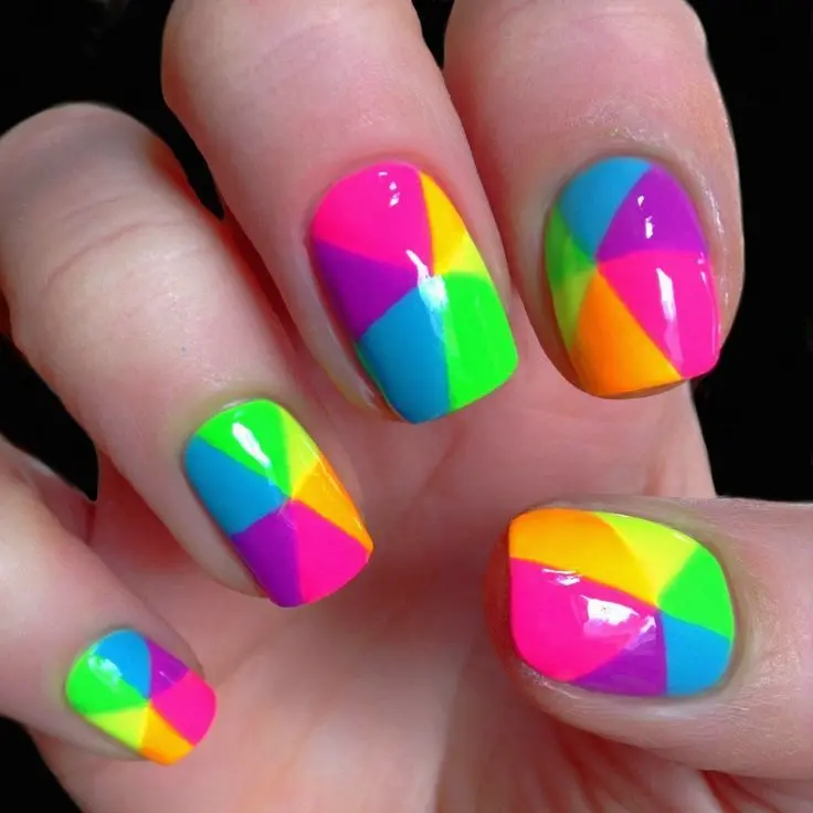 These short squoval nails present a unique geometric design with sharp, intersecting lines of neon colors. The look combines the vibrancy of a full rainbow palette, perfect for a funky and artistic style.