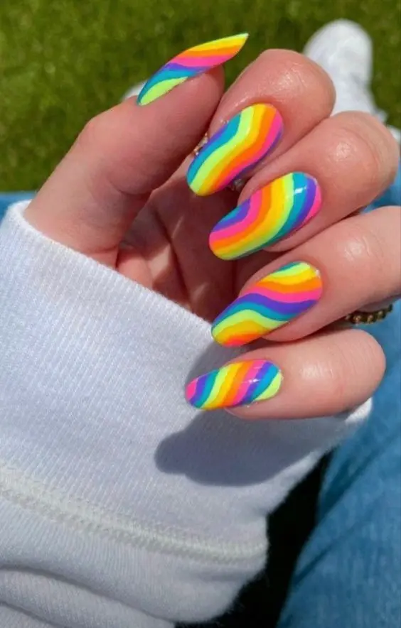 These oval nails are adorned with horizontal neon rainbow stripes, presenting a cheerful and bright appearance. The stripes cover the entire nail, creating a bold statement perfect for summer days and festival seasons.