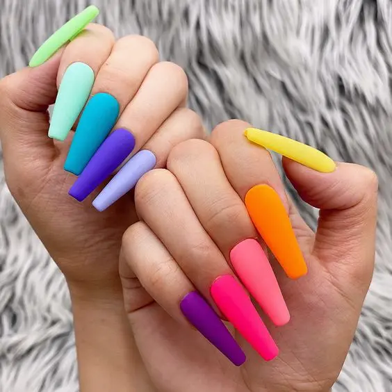 Simple yet striking, these long, straight nails display a matte finish in an array of neon colors. Each nail is a different hue, creating a rainbow effect that is both bold and minimalist, perfect for any season.