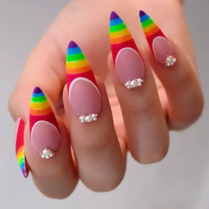 These nails feature a bold and elegant design with neon rainbow stripes on nude stiletto nails, accented with small pearls. The colorful stripes and delicate pearls create a sophisticated yet playful look, ideal for making a stylish statement.