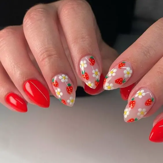 Classic red and white strawberry nail design with a glossy finish, featuring red nails complemented by nails with white backgrounds and tiny strawberries. This design is a timeless choice for those who appreciate vibrant and striking nail art.