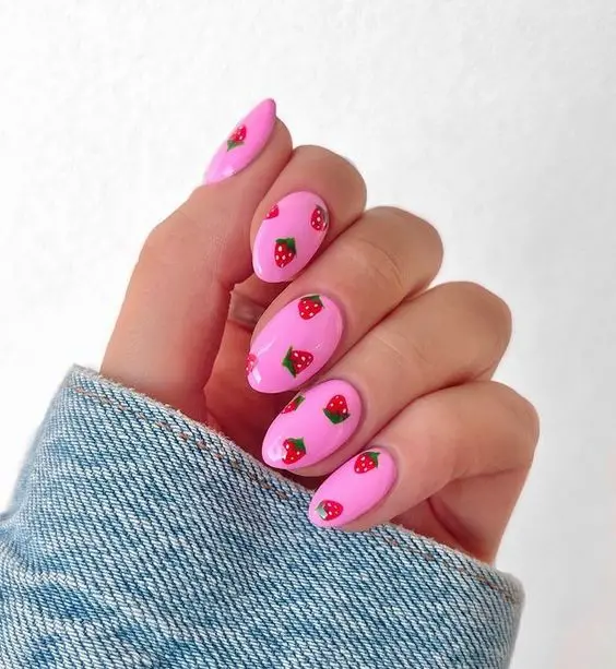 Soft pink nails provide a charming canvas for small red strawberries. This design is perfect for those who prefer a subtle yet cute nail art that pairs well with everyday outfits and special occasions alike.