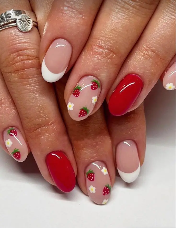 Combining classic and playful elements, this manicure uses rounded-shaped nails with a soft clear base, detailed with strawberries and tiny white flowers. The mix of solid red and transparent designs adds sophistication, making it suitable for both casual and formal occasions.