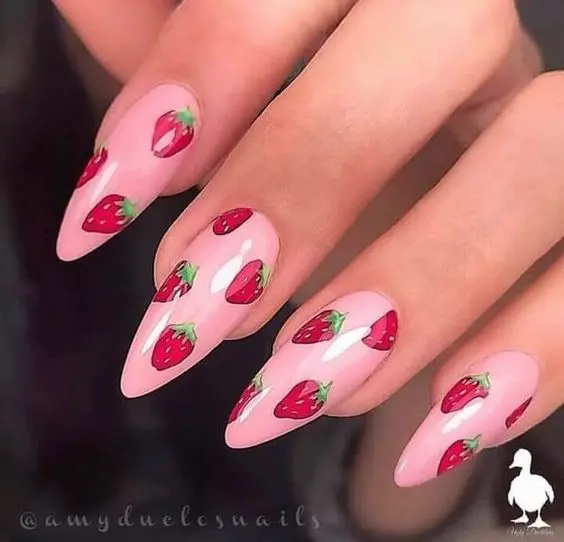 Sleek stiletto nails showcasing a minimalist design with single strawberry accents on a soft pink background, ideal for those who appreciate subtle yet stylish nail art.