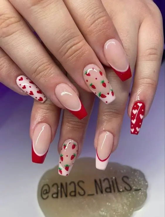 Featuring a playful mix of almond and ballerina shapes, this manicure combines glossy red tips with strawberry and polka dot patterns on a sheer pink base. The design is both whimsical and stylish, perfect for adding a fun twist to any outfit.