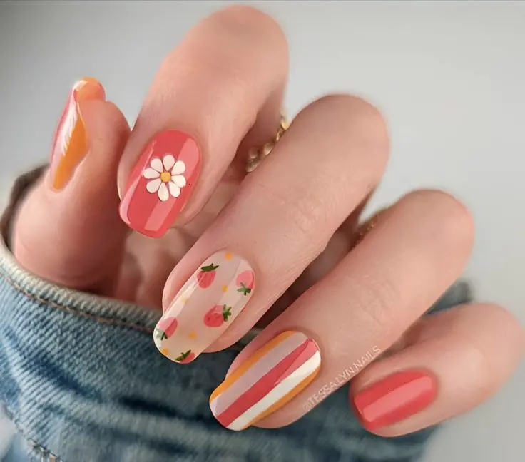 This manicure offers a cheerful blend of orange and pink hues on short squoval nails, accented with strawberries and geometric patterns. The light, airy colors paired with simple fruit motifs provide a playful yet chic look ideal for everyday wear.