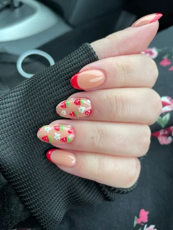 This charming set offers a combination of opaque nude and strawberry patterned designs on rounded nails. Vivid red strawberries with green accents pop against the soft background, creating a delightful contrast suitable for a fresh, everyday look.