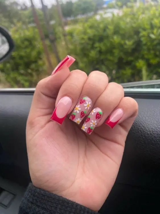 Elegant yet playful, this manicure combines a bold red French tip with a strawberry and floral pattern over a clear base, making it suitable for both casual and more formal occasions.