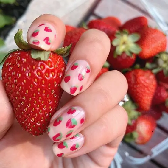 These elegant squoval nails feature a playful design with pink strawberry and green accents on a translucent base. The look is fresh and youthful, perfect for casual outings.