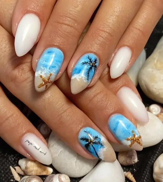 Stiletto nails with a stunning beach scene, featuring detailed palm trees and starfish on a sandy background. The blue and beige hues create a tranquil summer look, ideal for beach lovers.