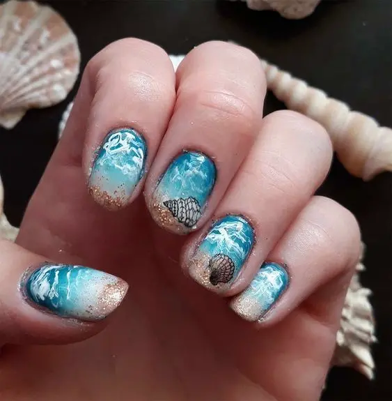 Oval nails displaying a detailed ocean wave design. The mix of blue and white shades creates a dynamic and refreshing summer look, perfect for beach lovers.