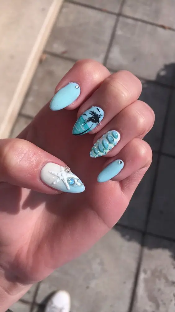 Featuring oval nails, this design combines light blue and white waves with 3D starfish and palm tree art. The detailed textures and summery colors create a lively and refreshing beach-inspired look, perfect for the summer season.