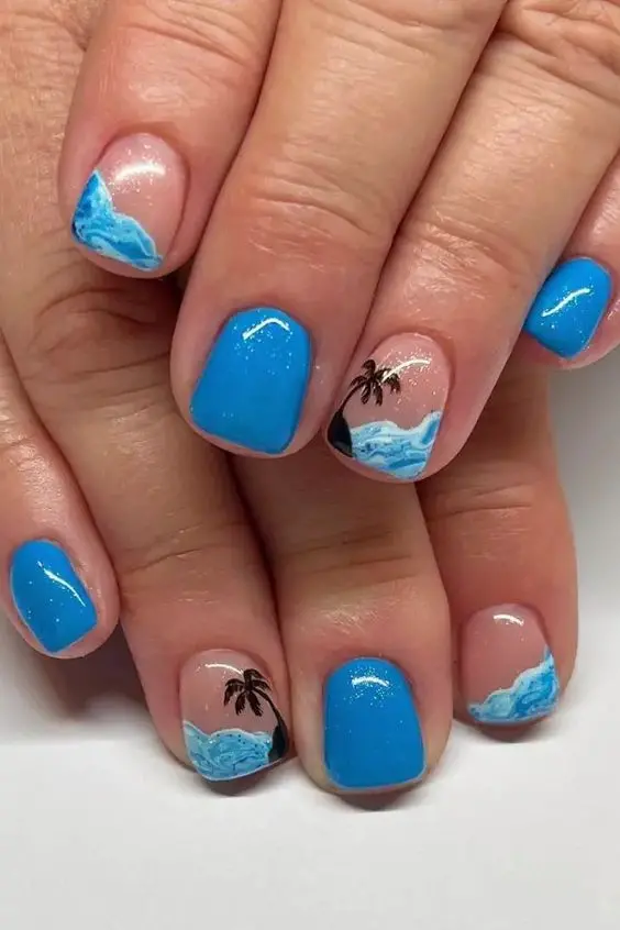 Short, square-shaped nails with blue and nude gradients, accented by small palm trees and waves. This minimalist design is perfect for a refreshing and serene summer style.