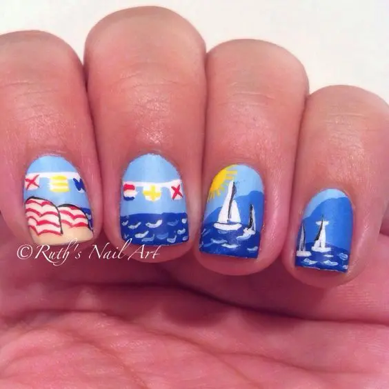 Short nails with a vibrant blue base, decorated with sailboats and nautical flags. This playful design is perfect for a lively summer day at sea.