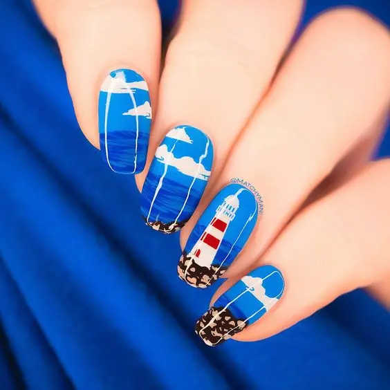 Oval-shaped nails with deep blue ocean waves and a striking lighthouse design. This bold and nautical look is perfect for a stylish summer adventure.