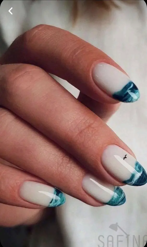 With an almond shape, this set features a minimalist approach to beach nail art. The design includes clean blue tips with subtle wave detailing. The simplicity and elegance of the design make it versatile for various summer occasions, highlighting the natural beauty of the beach.