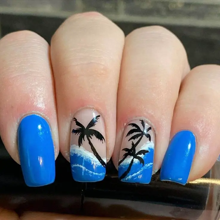 Square-shaped nails featuring vibrant blue waves and black palm tree silhouettes. This tropical design is ideal for a sunny beach vacation look.