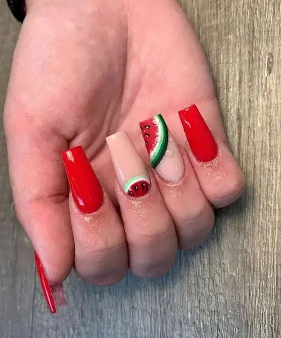 A juicy summer affair with glossy red nails, complemented by a slice of watermelon design on a transparent base, adding a splash of cool to the heat.