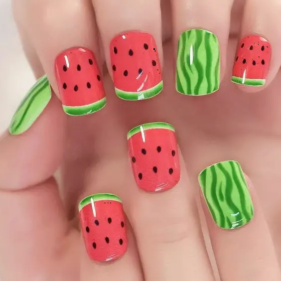 Cheerful, squoval-shaped nails painted in watermelon red and green with realistic seeds, embodying the playful spirit of summer.