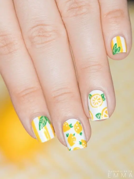 Short, square nails present a summer citrus medley with lemon and orange slice patterns against a crisp white backdrop, refreshing for sunny days.